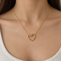 Gold-tone open heart pendant necklace worn with a neutral neckline
