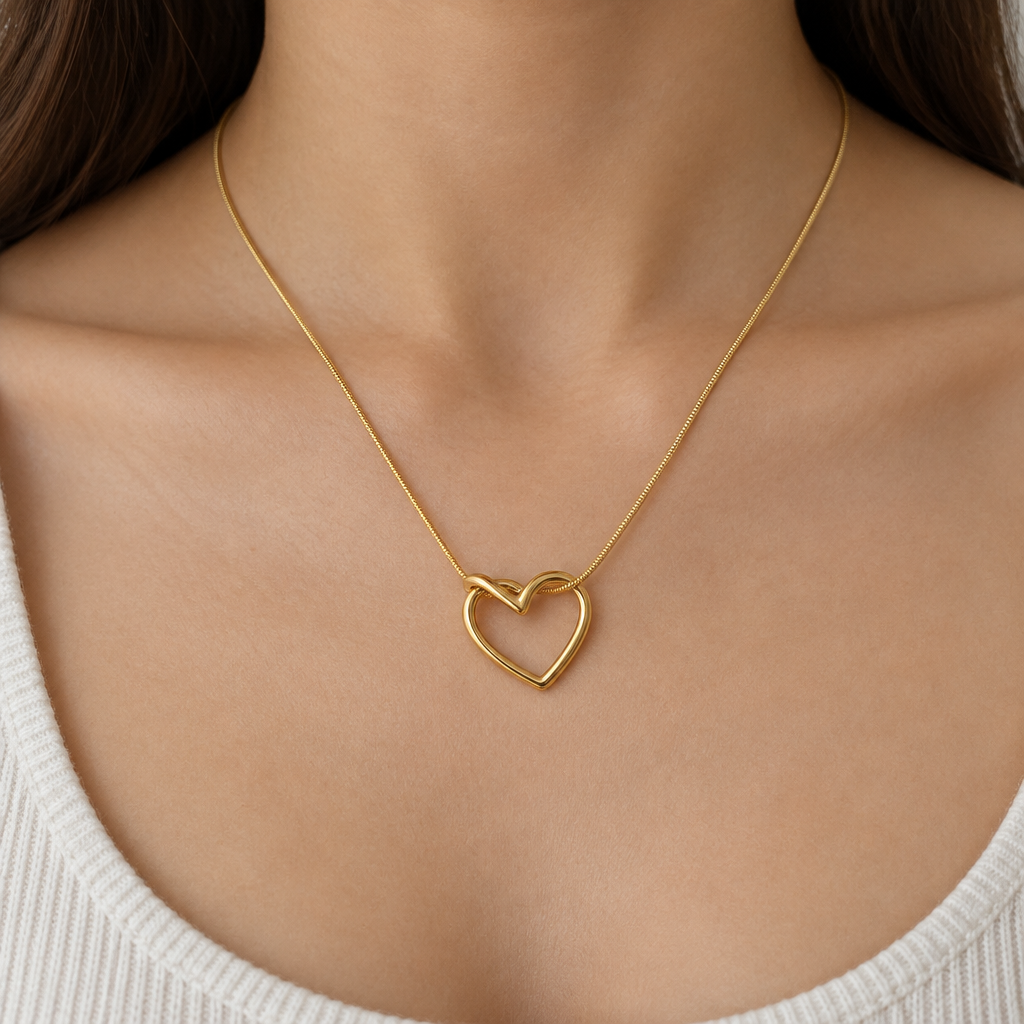 Gold-tone open heart pendant necklace worn with a neutral neckline
