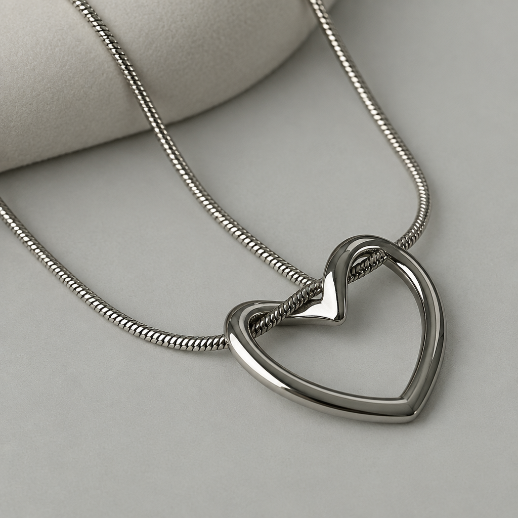Close-up of silver-tone open heart pendant with curved top detail