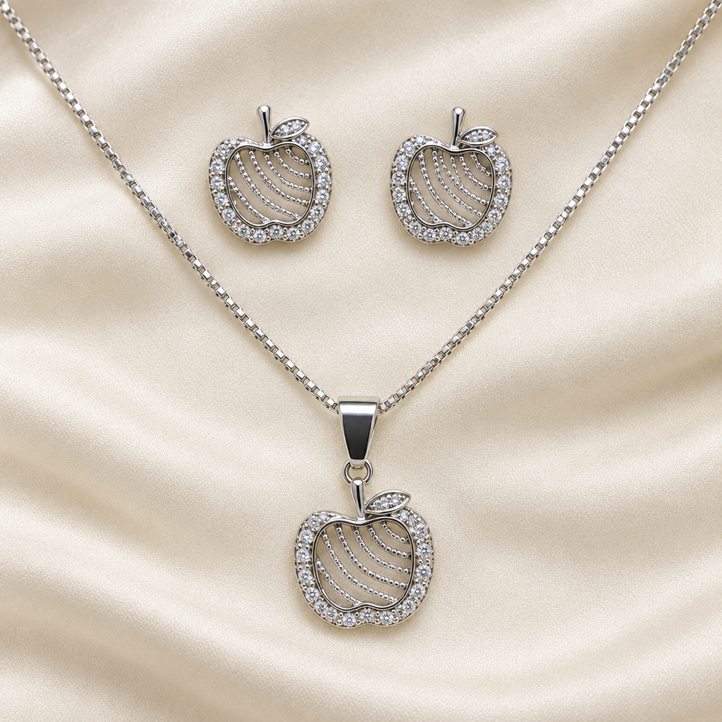 Silver-tone apple pendant necklace and stud earrings on ivory fabric