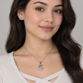 Model wearing silver-tone heart-loop pendant necklace and matching stud earrings