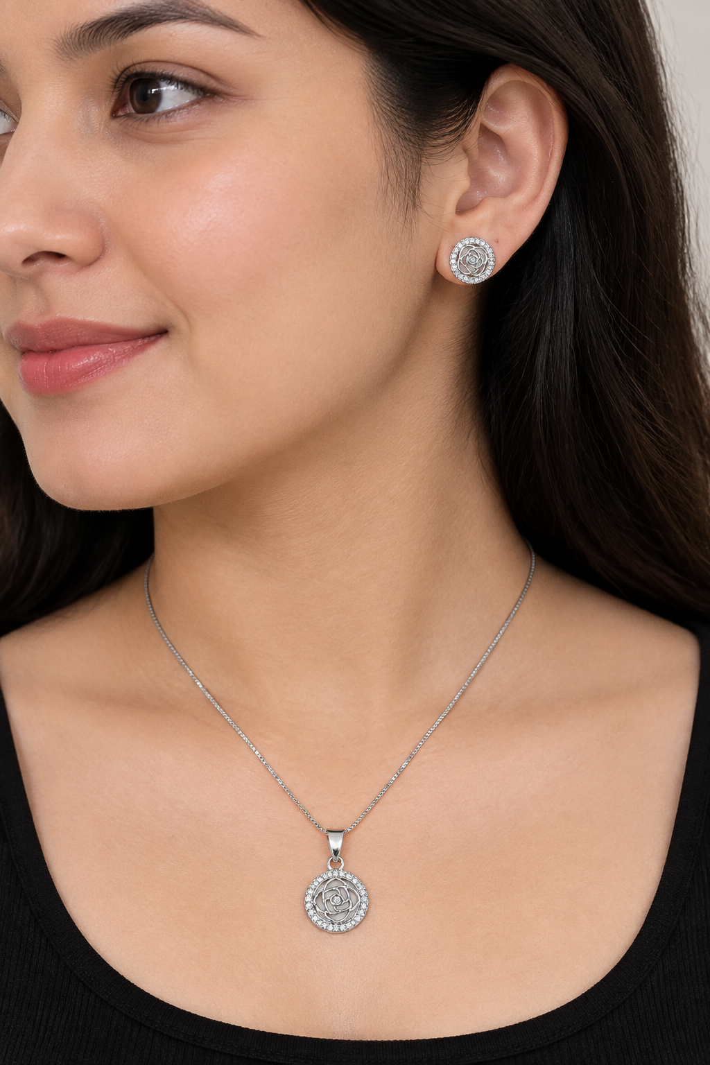 Styled model wearing round rose pendant and matching stud earring