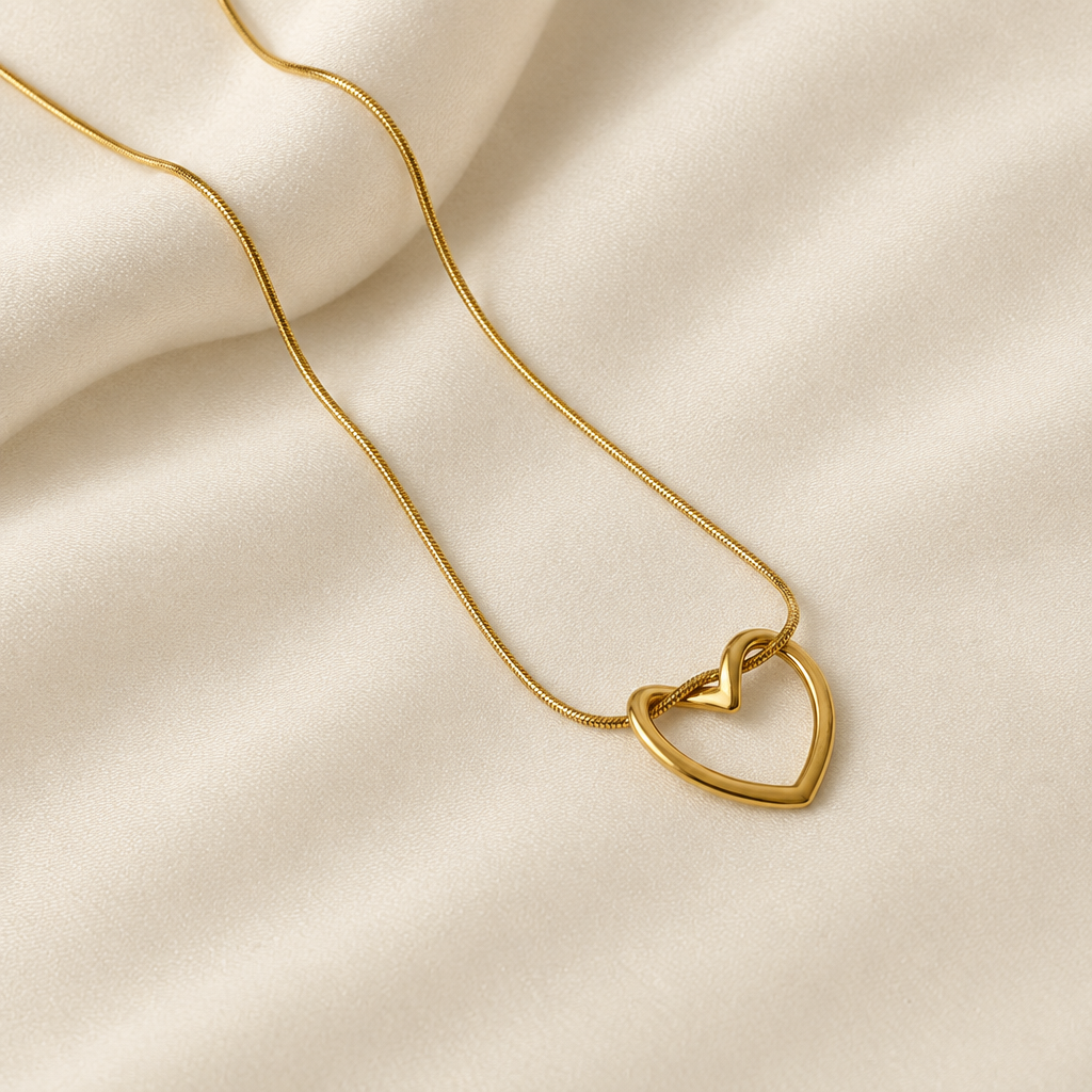 Open heart pendant necklace laid on cream fabric
