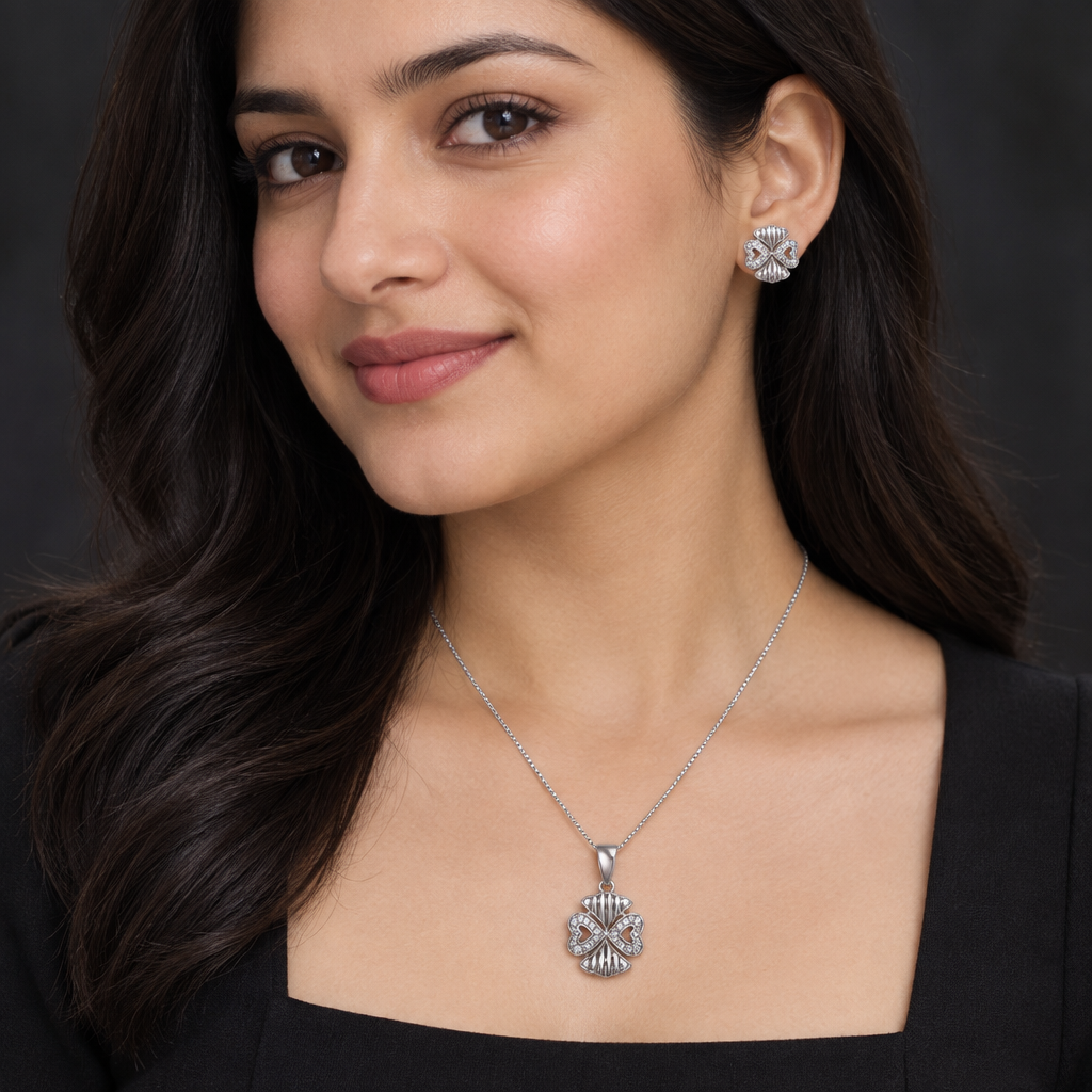 Model wearing silver-tone pendant and matching studs with a dark outfit