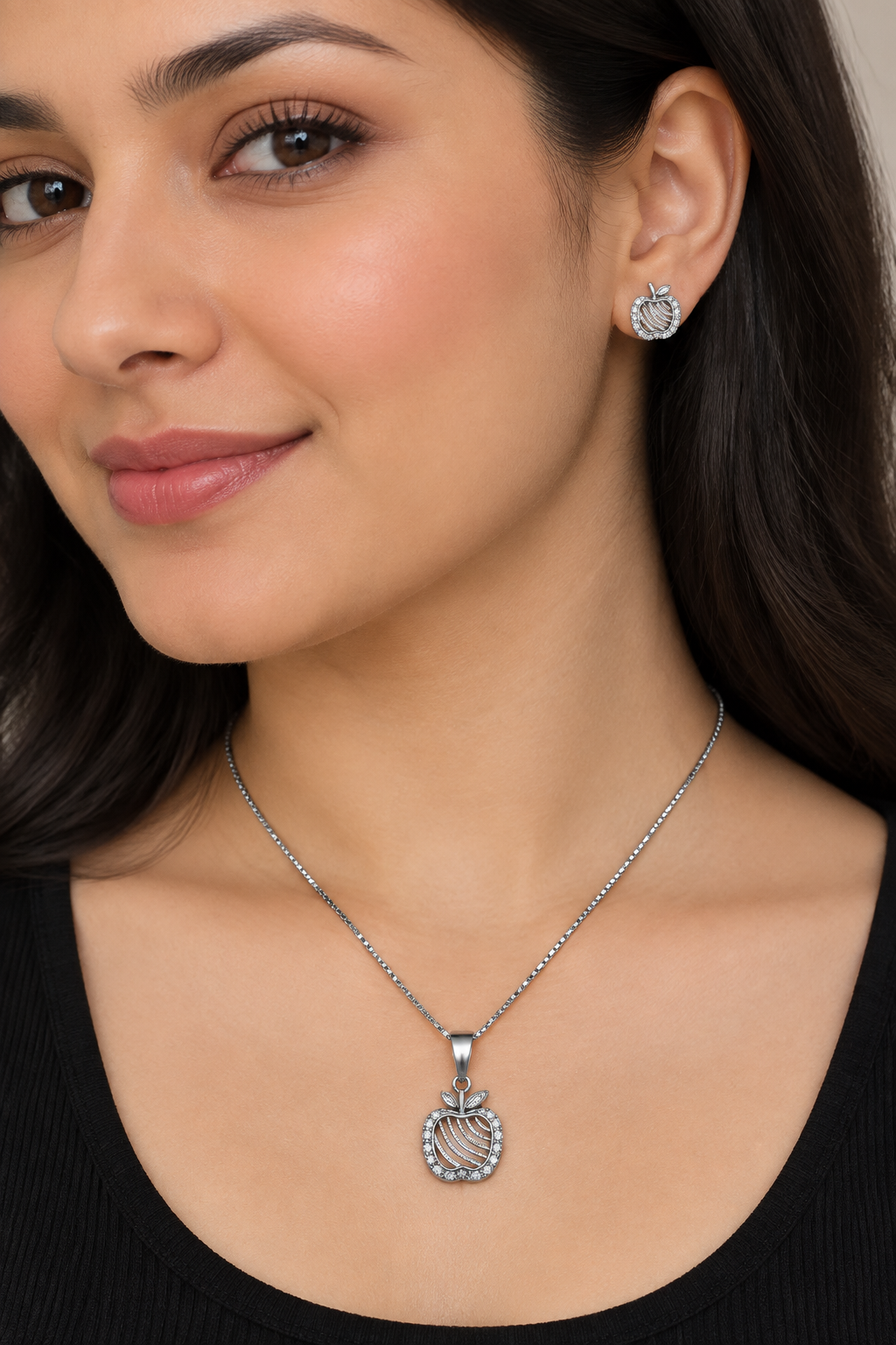 Styled model wearing apple pendant necklace and matching stud earring