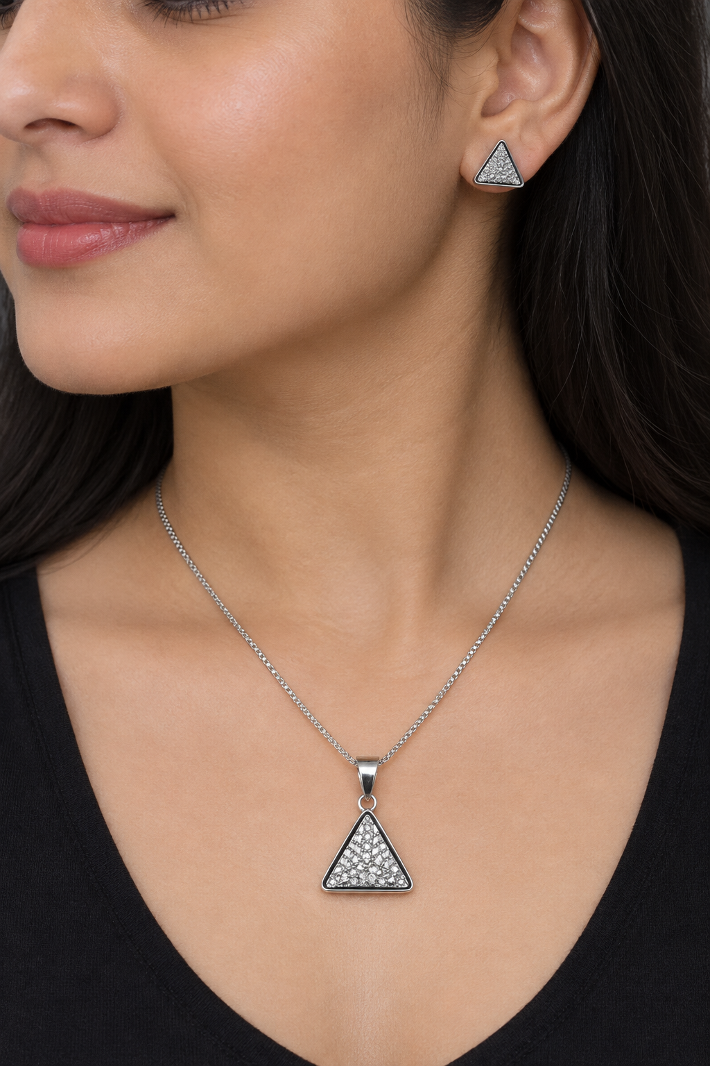 Styled model wearing silver-tone triangular pendant necklace and matching stud earring