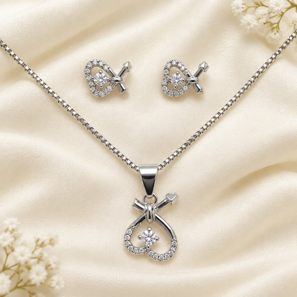 Silver-tone heart-loop necklace and matching earrings on pale fabric