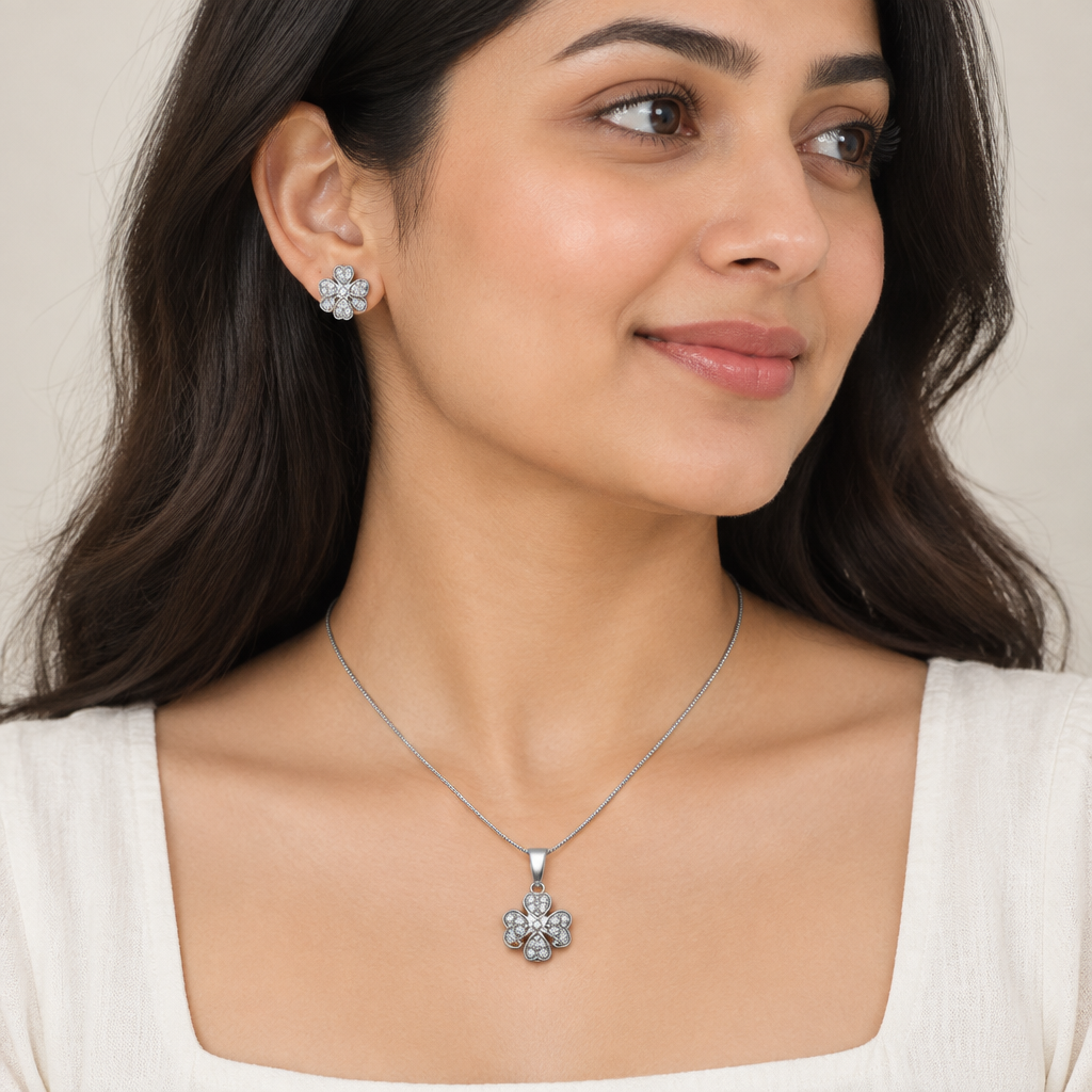 Model wearing silver-tone floral pendant necklace and matching stud earrings
